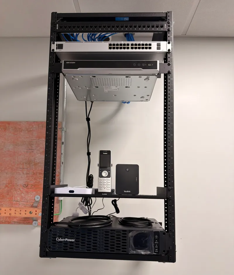 Wall-mounted network rack with patch panel, switch and UPS installed in Maine