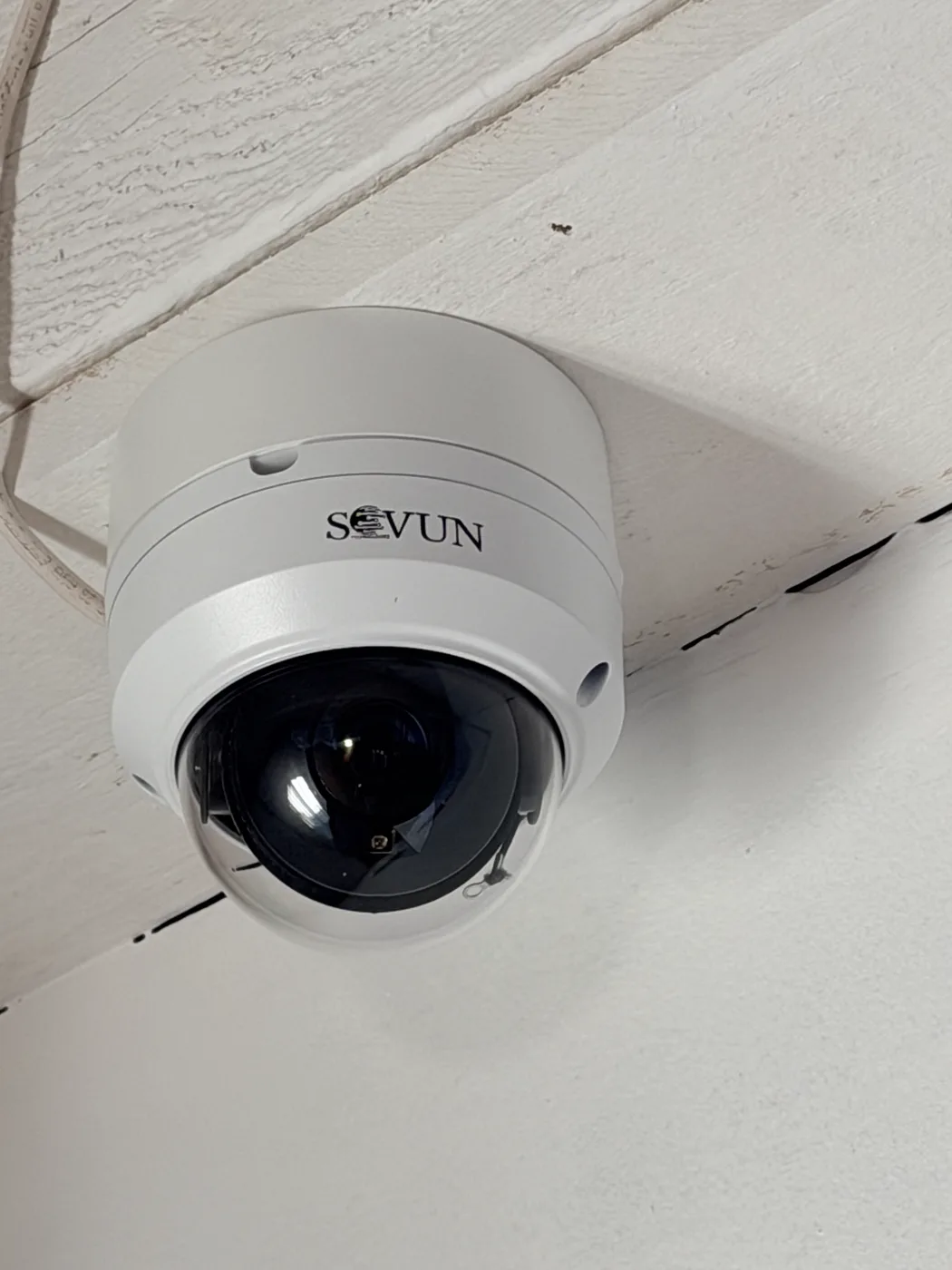 Dome security camera installed on a white wall